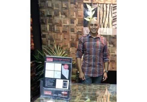 Serge with display of Renaza Wooden Wall Cladding and Luminosa light switch brochures